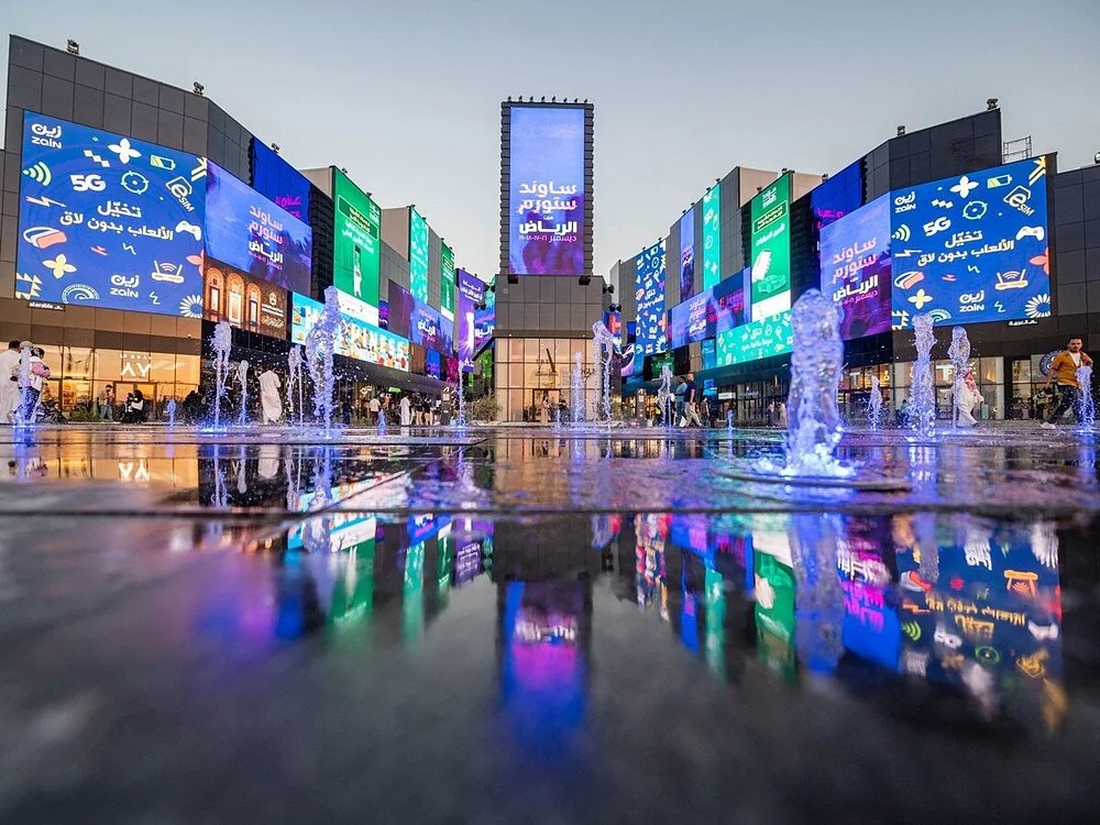 Large digital screens around a pedestrian plaza in Boulevard City