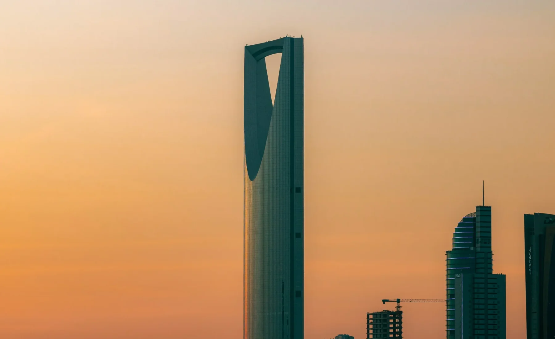 Kingdom Centre and nearby buildings against a golden sky