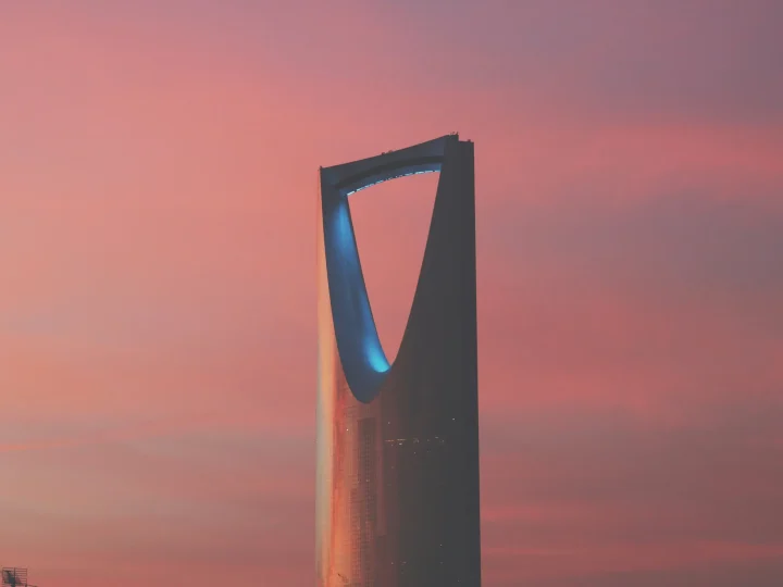 The upper section of Kingdom Centre against a pink evening sky