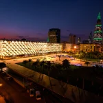 Illuminated patterned building facade and Riyadh towers at dusk