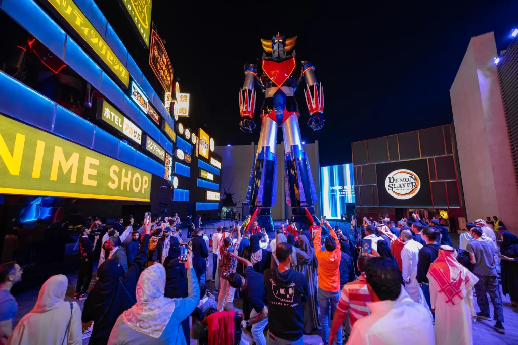 Visitors walking past illuminated anime displays at a Riyadh Season entertainment area