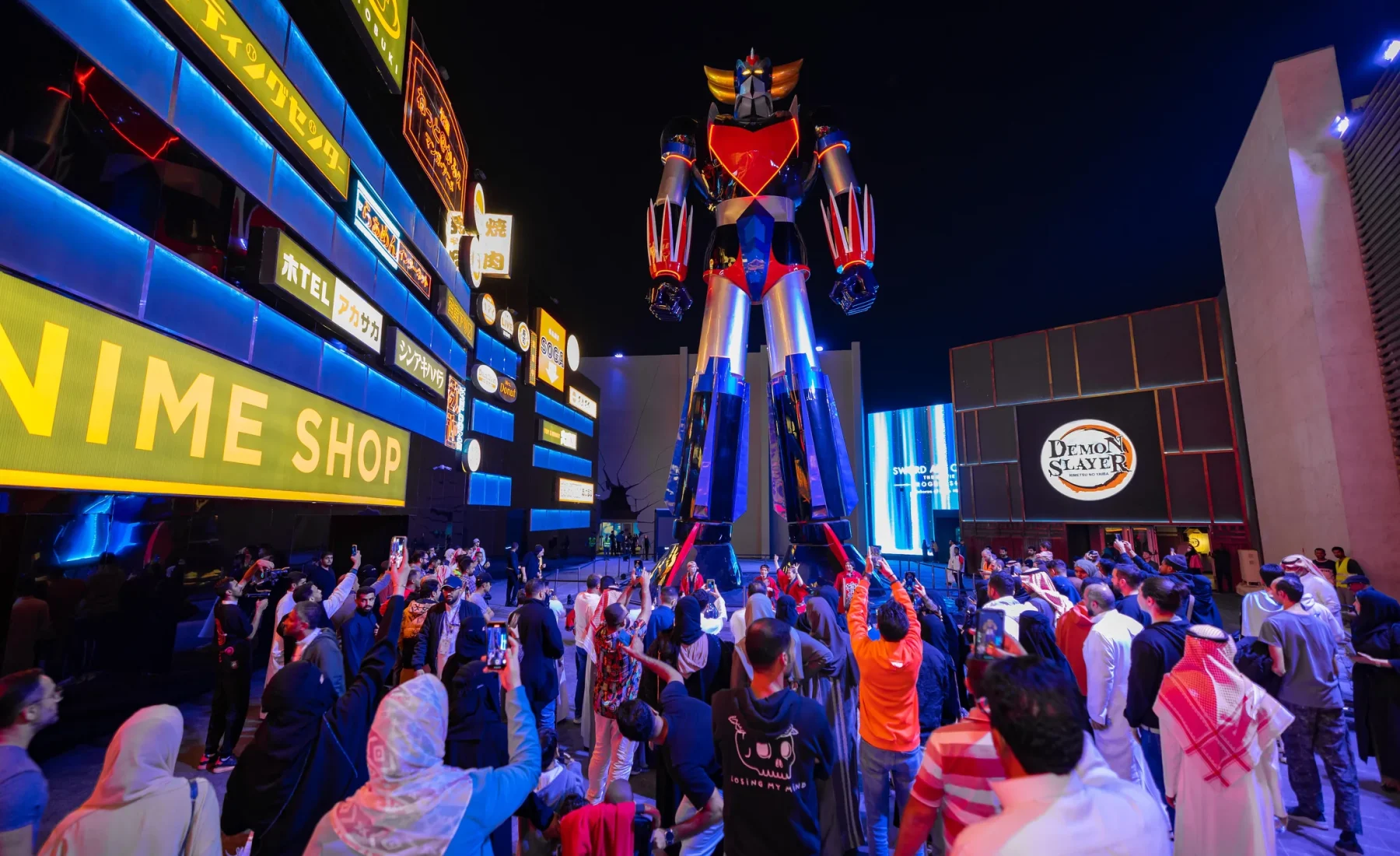 Visitors walking past illuminated anime displays at a Riyadh Season entertainment area