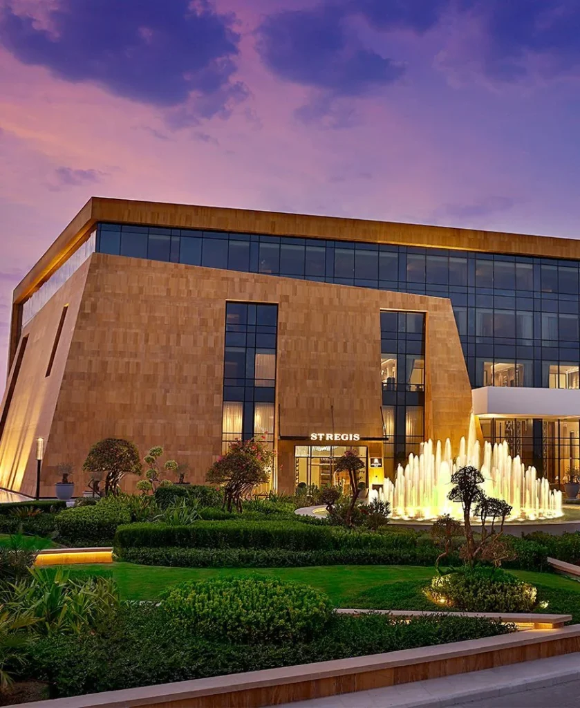 The St. Regis Riyadh entrance with landscaped gardens and illuminated fountains at dusk